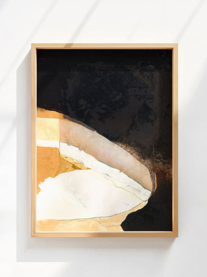 Framed abstract art with black, gold, and white colors on a white wall.
