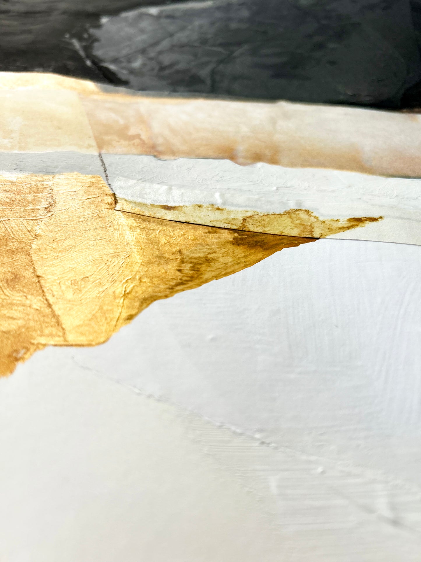 Close-up of a painted surface with gold and white paint