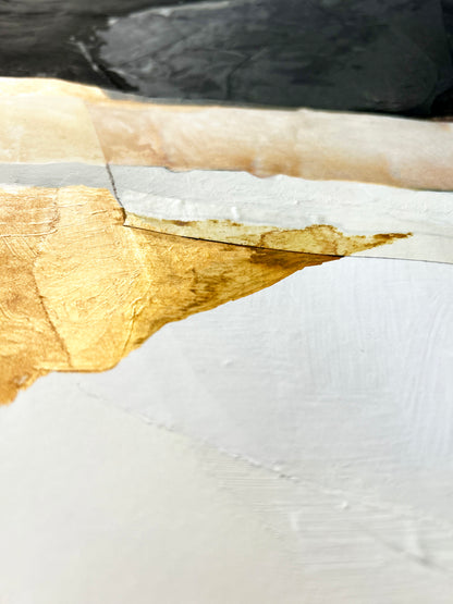 Close-up of a painted surface with gold and white paint