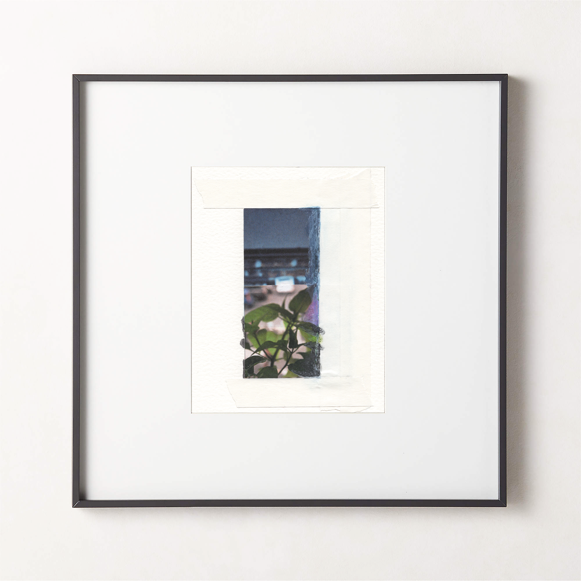 Mixed media photo collage with deep blue-gray painted surfaces, green botanical leaves, and architectural elements in a small black fame.