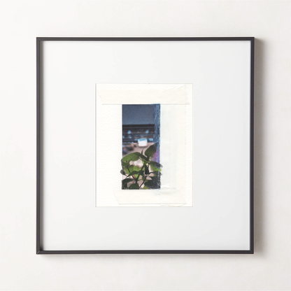 Mixed media photo collage with deep blue-gray painted surfaces, green botanical leaves, and architectural elements in a small black fame.