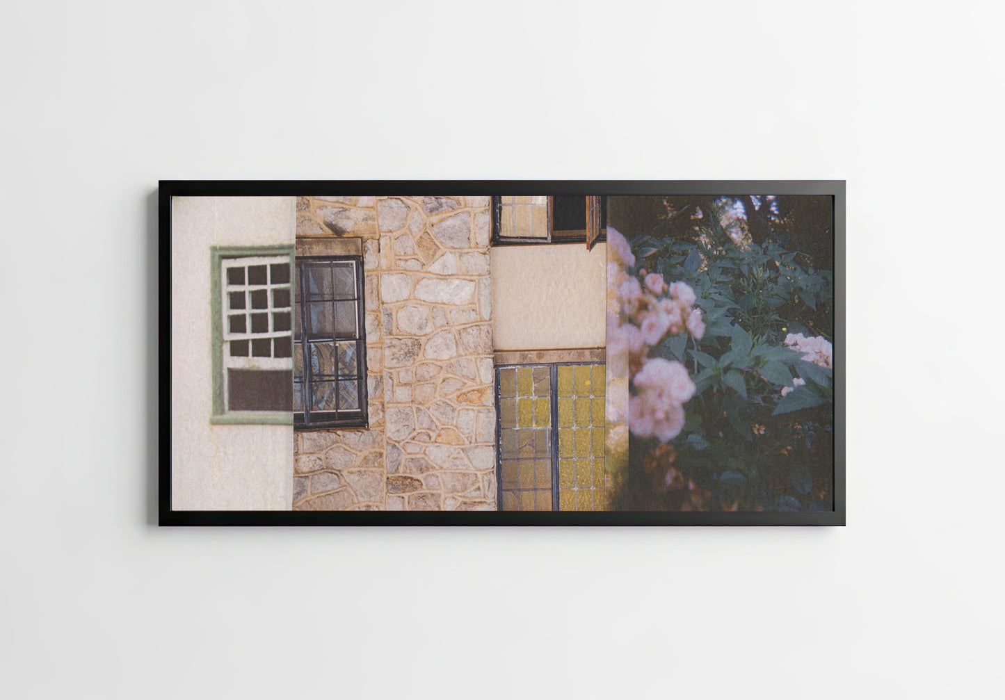 Framed collage of a stone wall with windows, a door, and flowers.