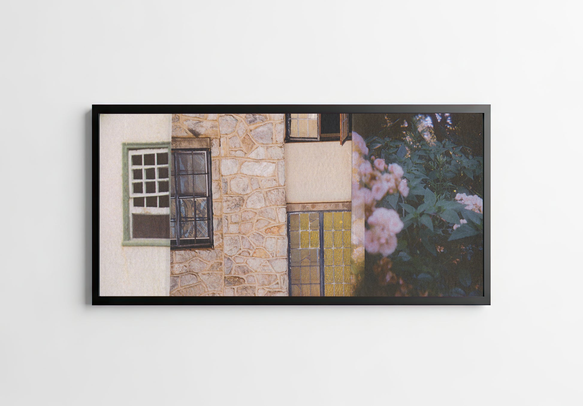 Framed collage of a stone wall with windows, a door, and flowers.