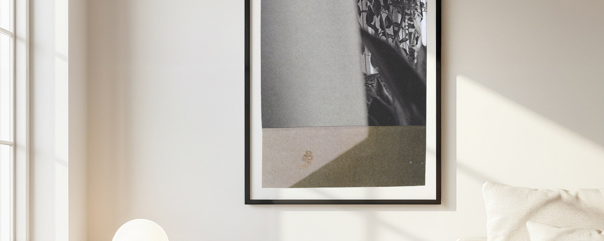 Framed black and white photo collage artwork on a wall with natural light
