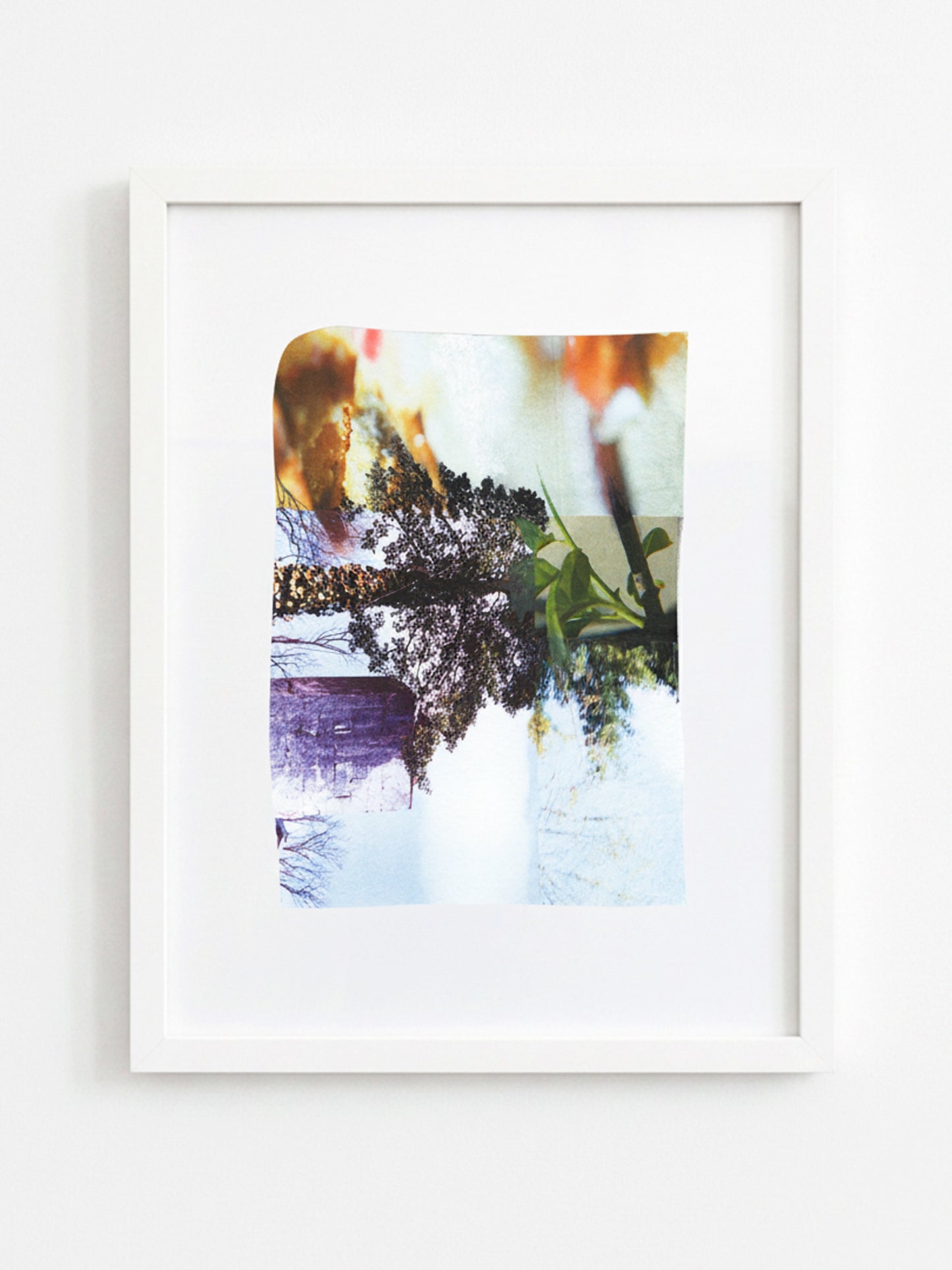 A framed abstract art print featuring a colorful, painterly composition with purple, green, orange, and white tones, presented in a white frame against a clean white wall.