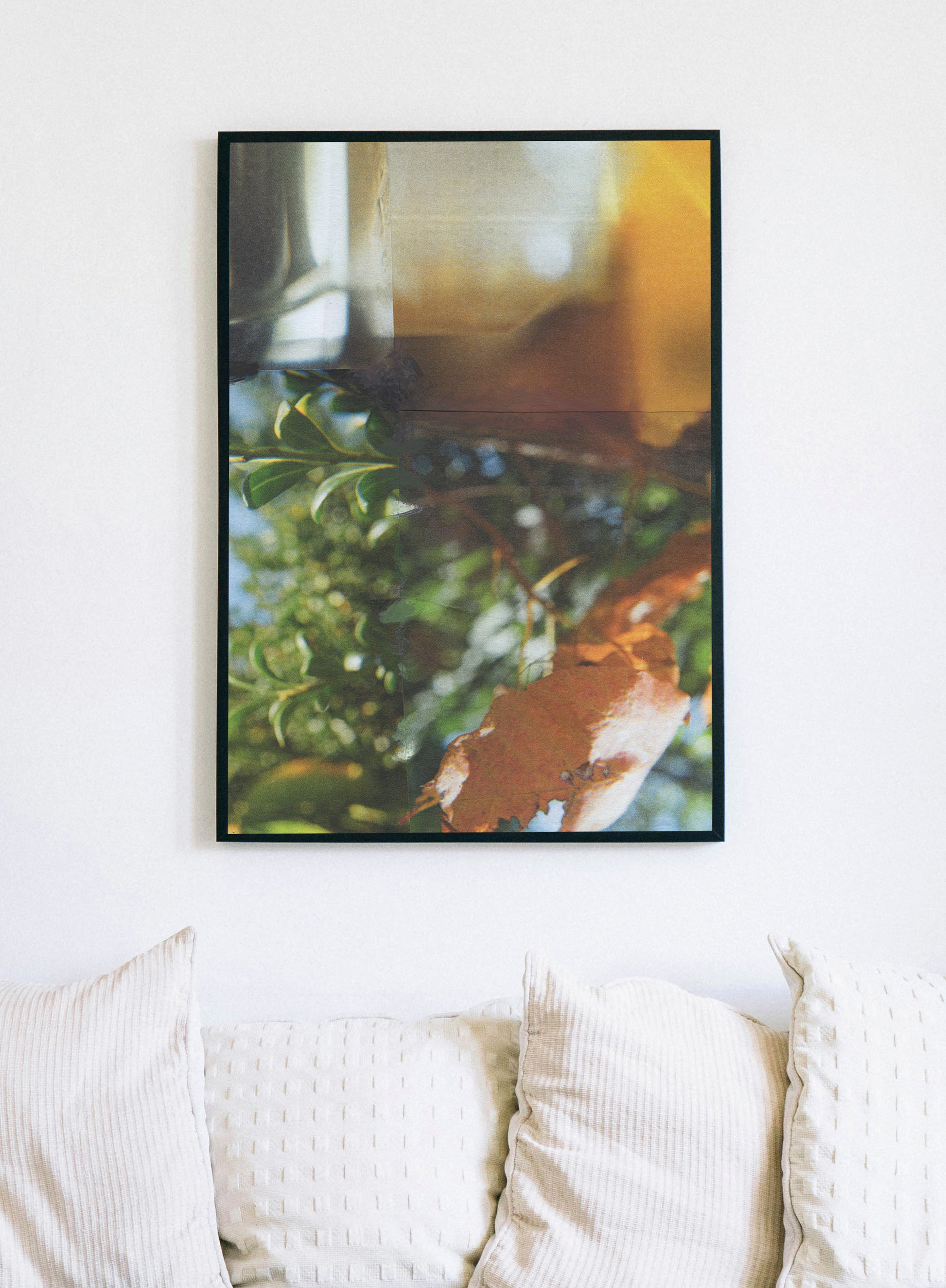 Framed canvas print of abstract collage with layered green botanical, amber, and blue.