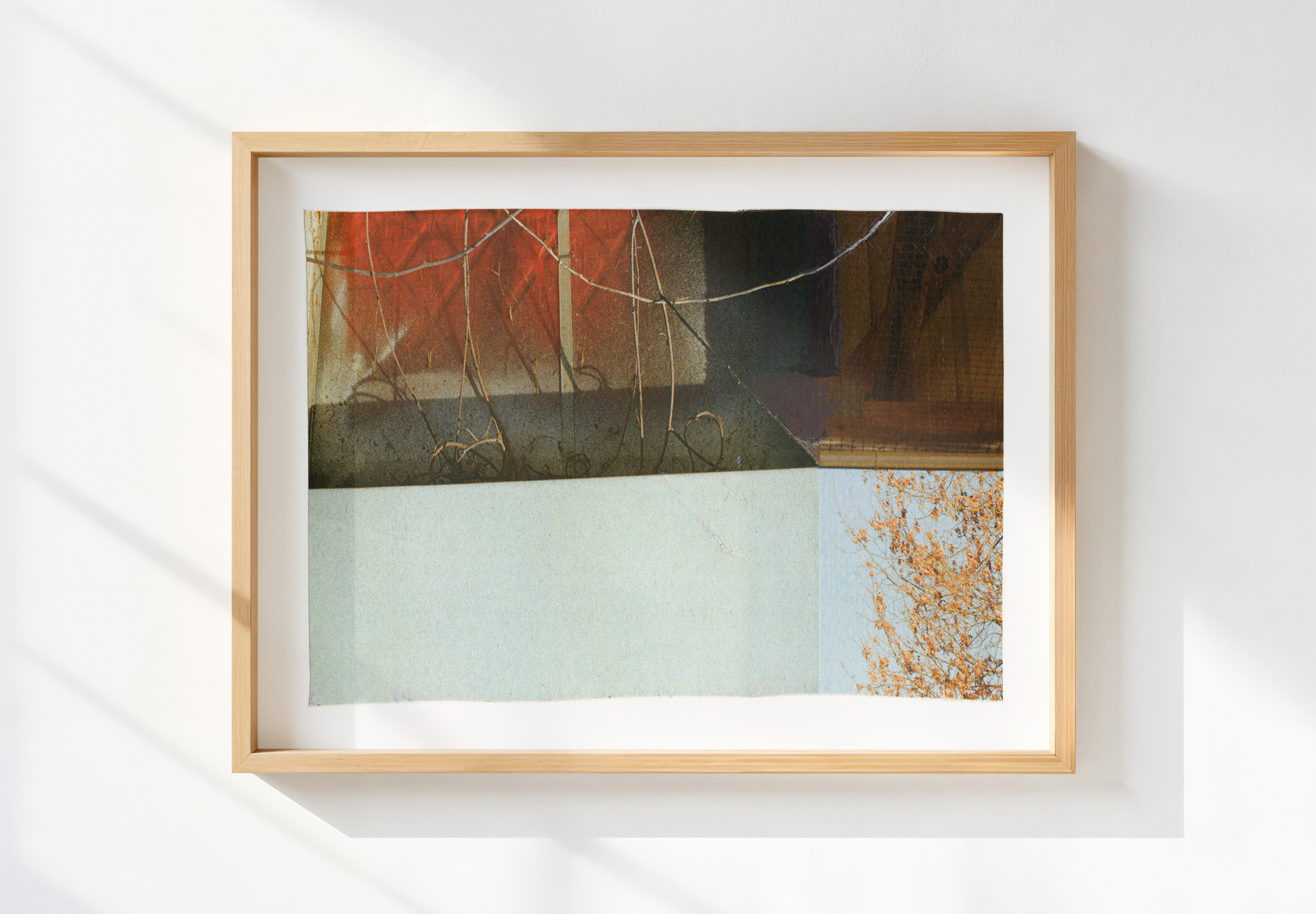 Photo collage with architectural elements and warm and cool tones in a wood frame.