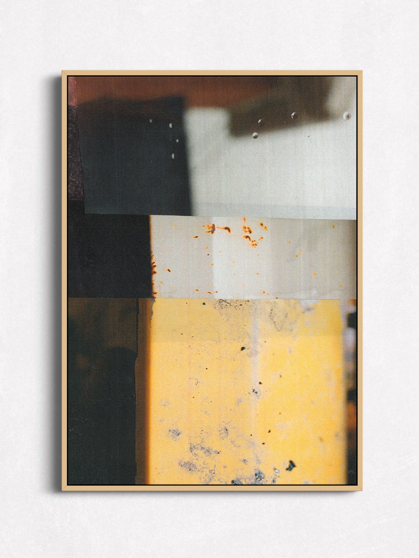 Abstract geometric art print with charcoal, cream, and golden yellow blocks in an oak floater frame.