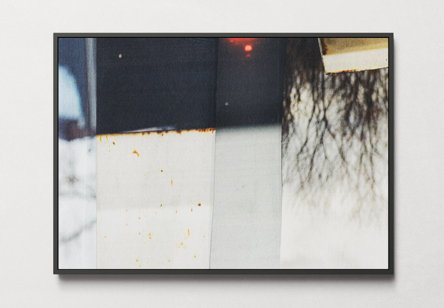 Framed canvas of photo collage with grays, blacks, and warm beiges with a touch of red.