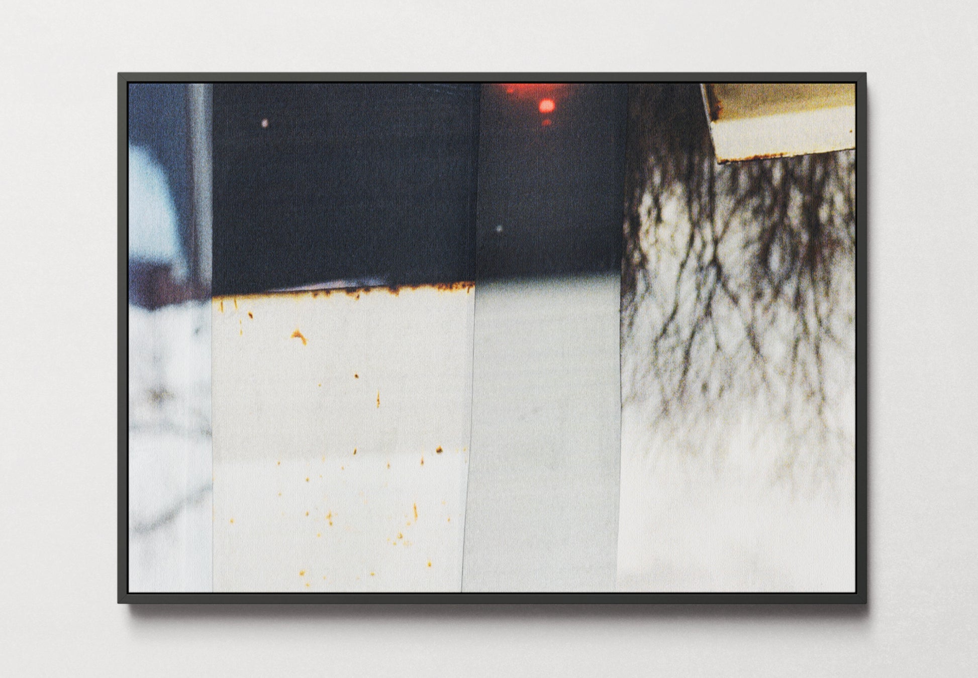 Framed canvas of photo collage with grays, blacks, and warm beiges with a touch of red.