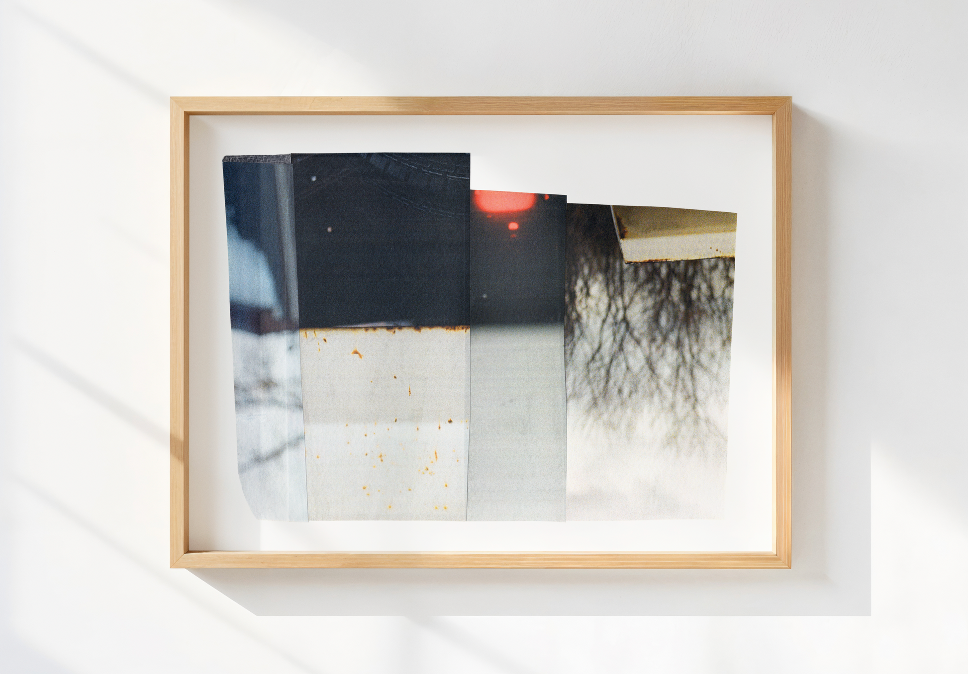 Photo collage with neutral tones and a touch of red in a raw wood frame.
