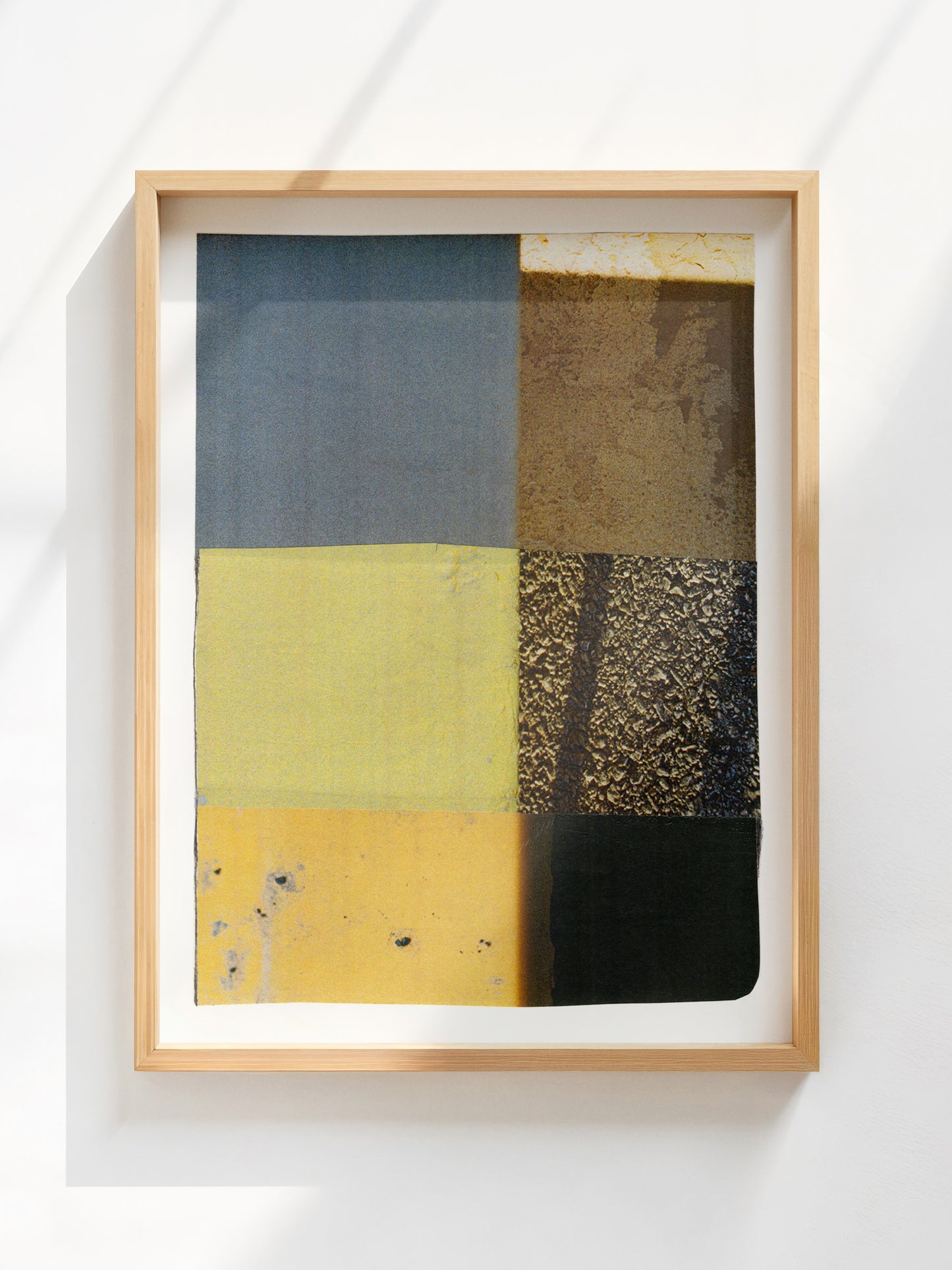 Framed geometric abstract photo collage with blue, yellow, green, and neutral tones. 