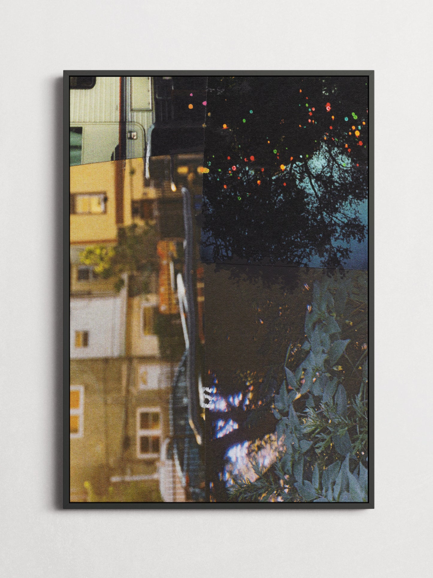 Collage 76 abstract art print in a thin black frame on a white wall, featuring a dark moody night scene with warm building lights and colorful bokeh.