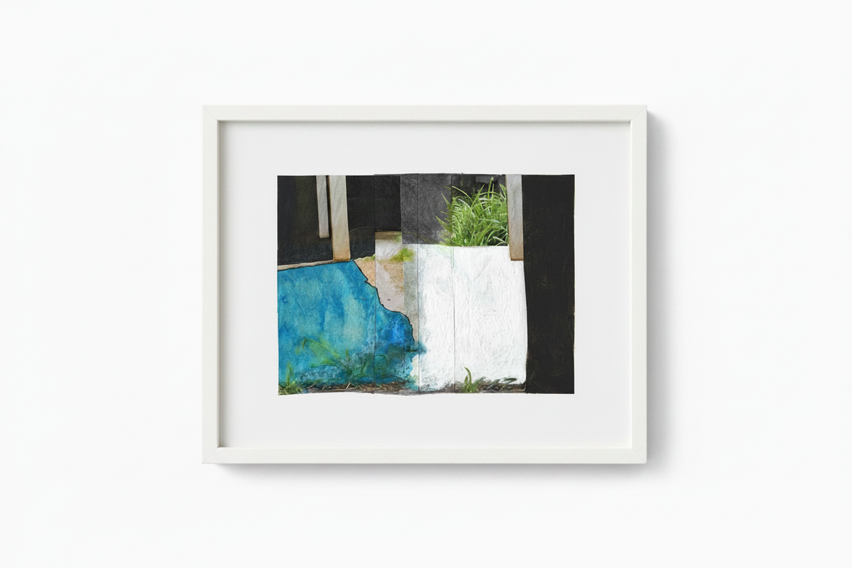 A framed abstract art print featuring a textured composition of blue, white, black, and green, presented in a white frame against a clean white wall.