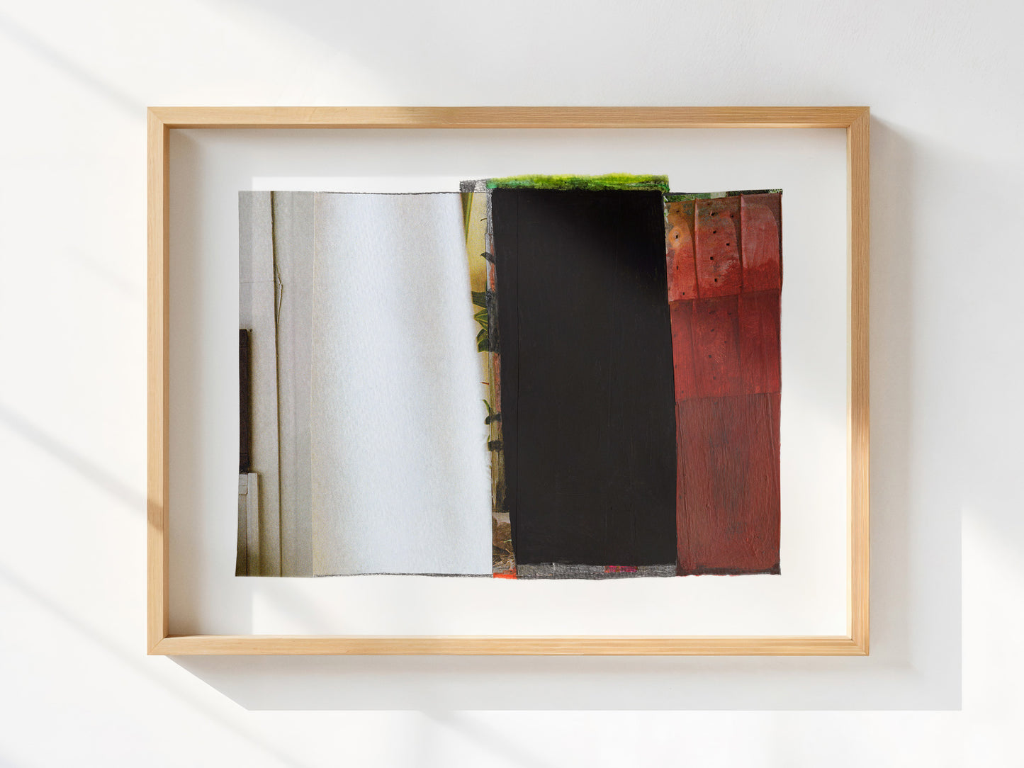 A framed abstract art print featuring vertical textured panels in white, black, and red, housed in a light natural wood frame and mounted on a white wall.