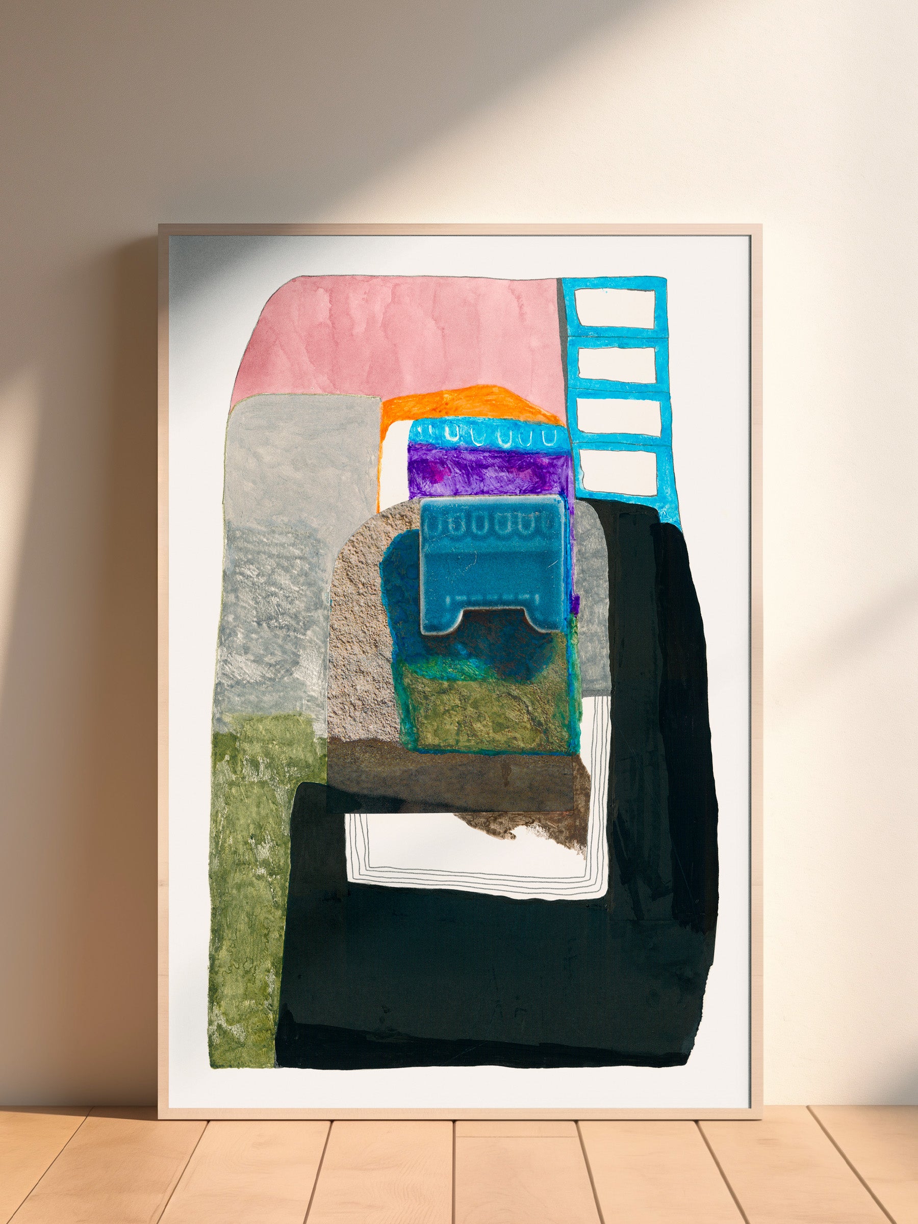 Framed abstract artwork with colorful geometric shapes on a white wall.