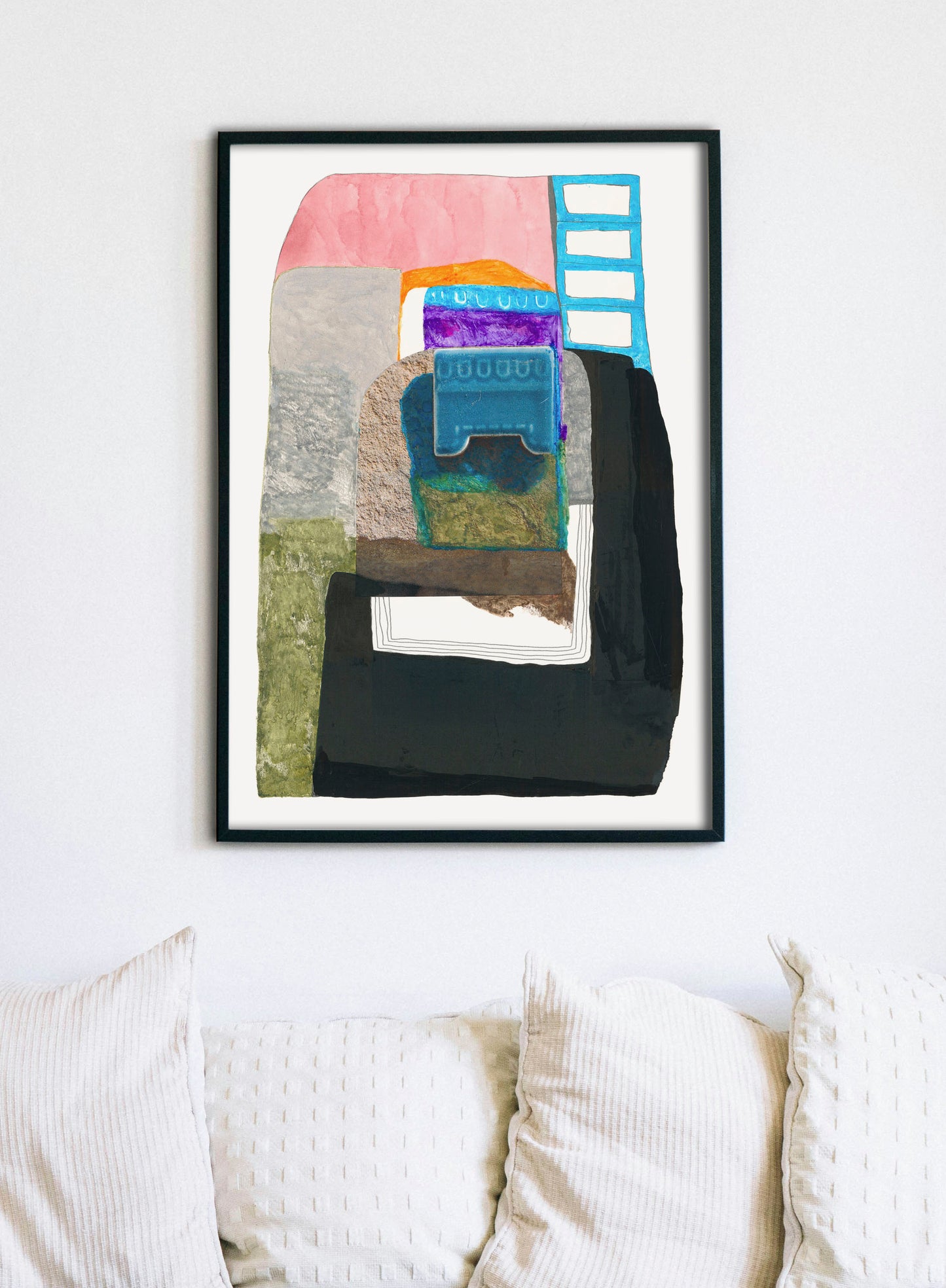 Abstract art piece with colorful shapes on a white wall above a sofa.