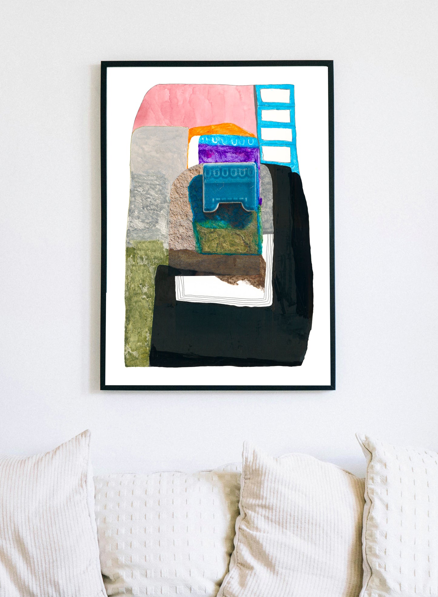 Abstract art piece with colorful shapes on a white wall above a sofa.