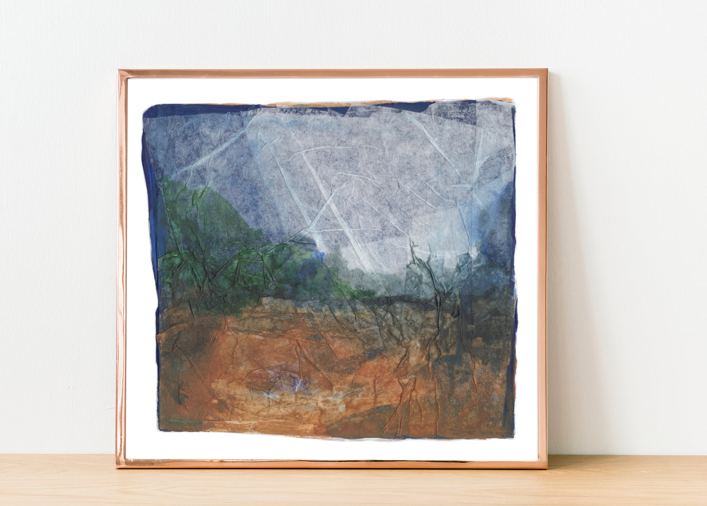 Abstract collage artwork with layered translucent paper, soft creases, and muted tones of blue, rust, and beige. The composition evokes a dreamlike landscape with a quiet, weathered texture. 