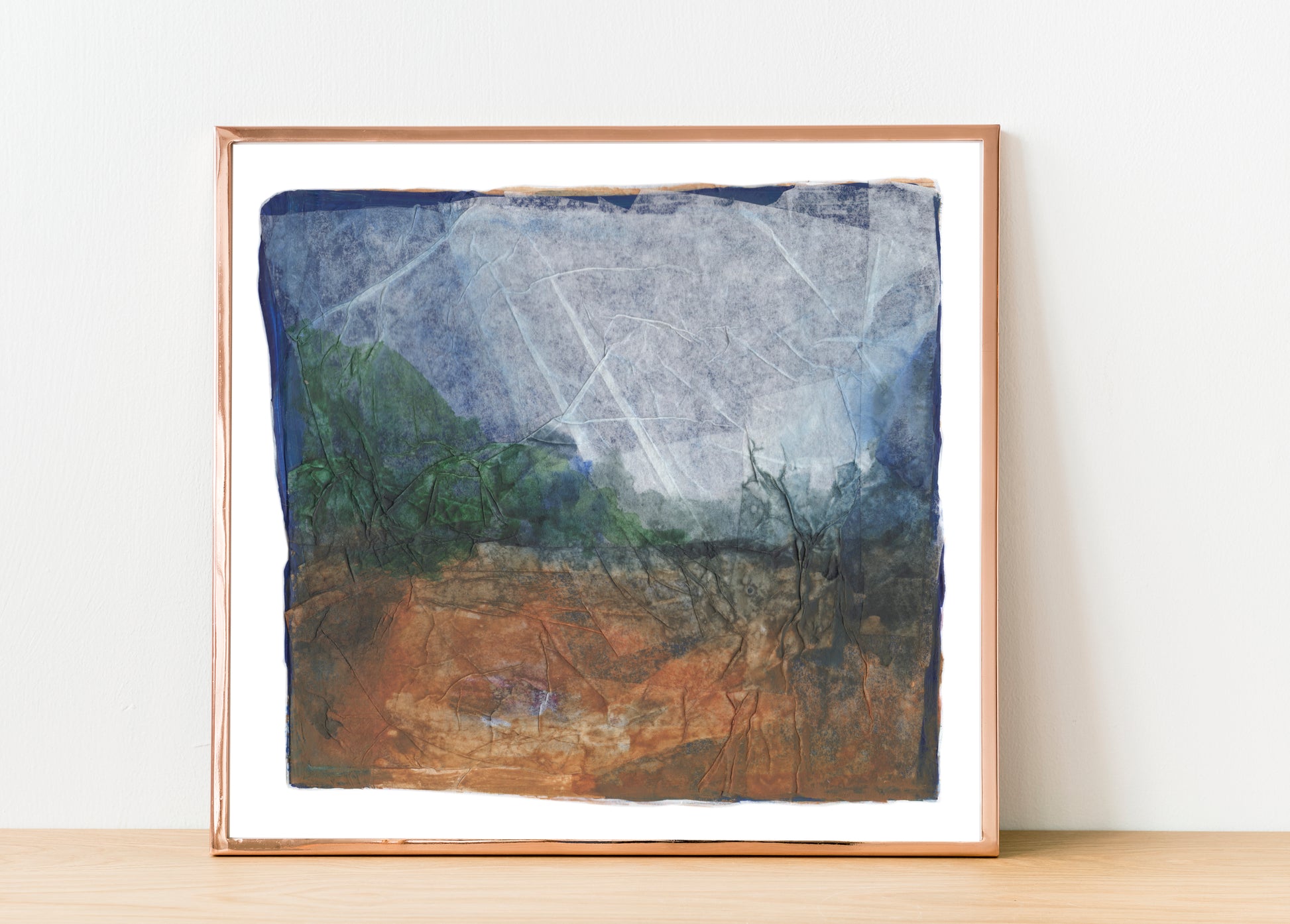 Abstract collage artwork with layered translucent paper, soft creases, and muted tones of blue, rust, and beige. The composition evokes a dreamlike landscape with a quiet, weathered texture. 