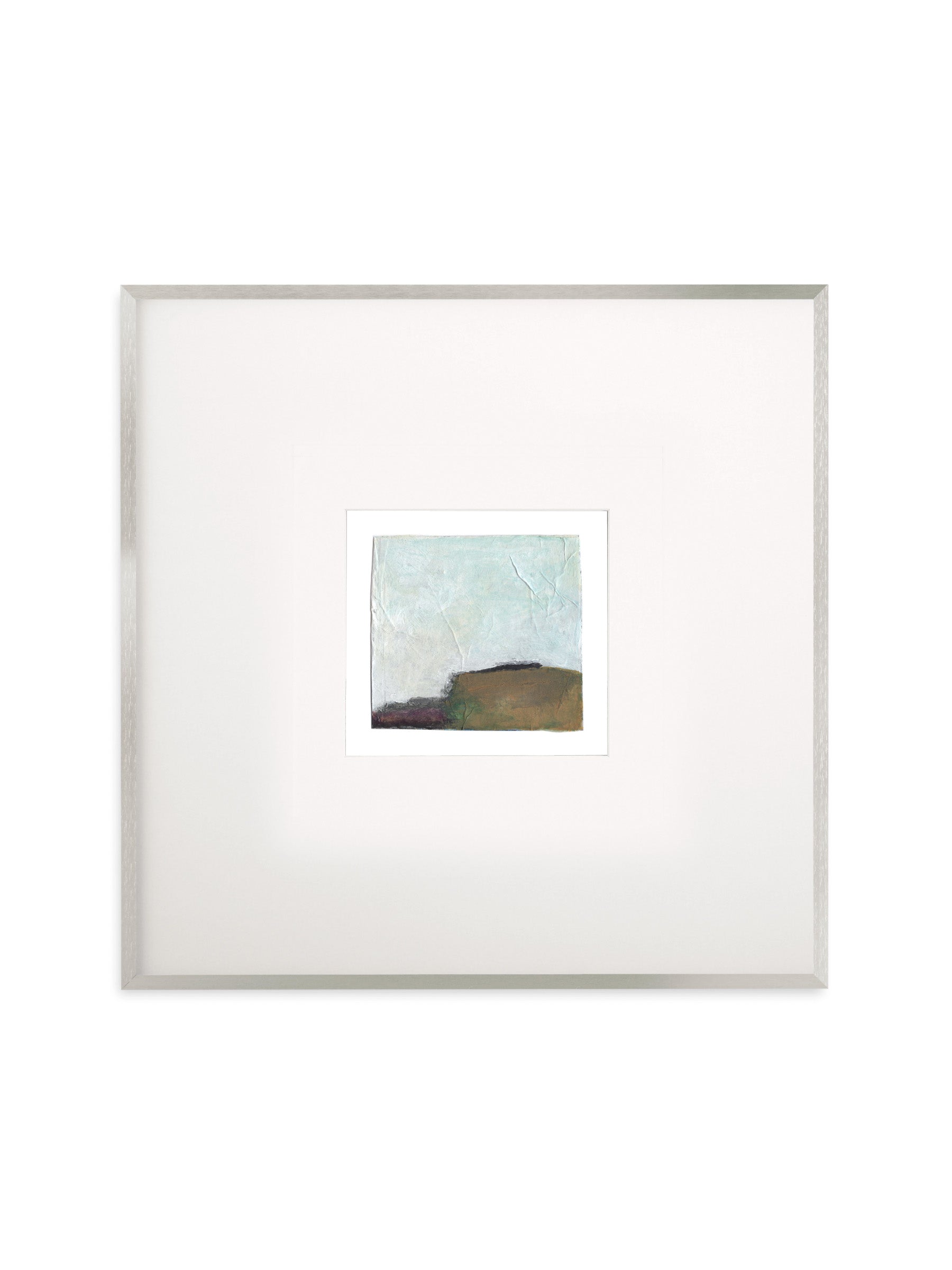 A square framed abstract art print featuring a textured light blue and brown landscape, presented with a wide white mat and a thin silver frame against a white background.