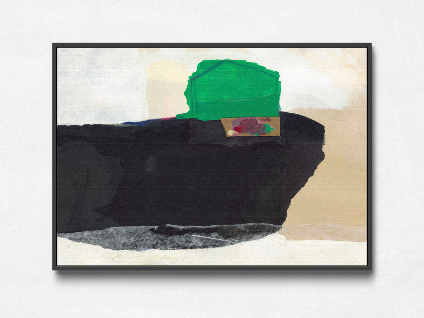 A framed abstract painting featuring a large black shape, a green block, beige and off-white areas, and a small red accent, shown against a light wall.