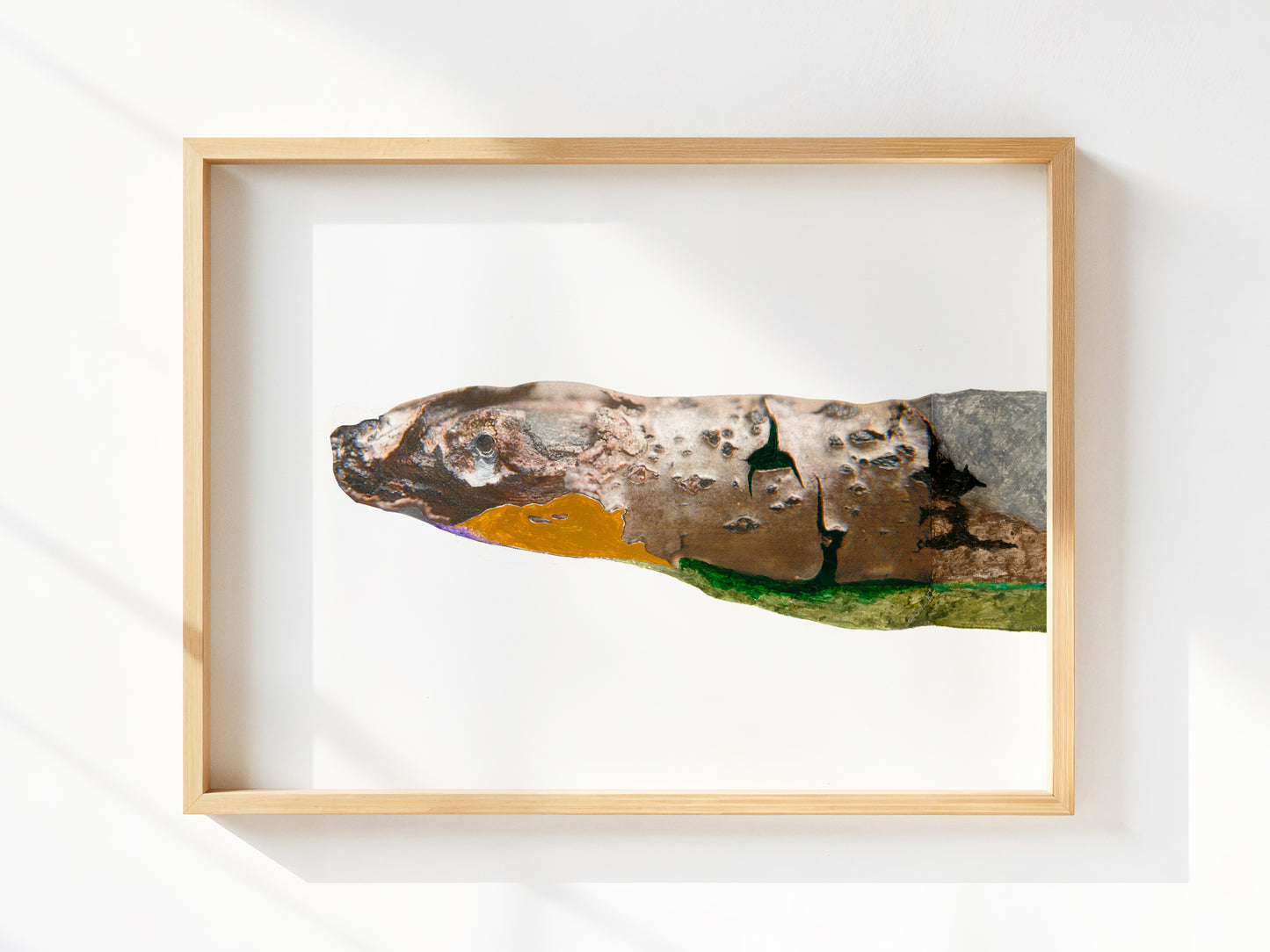 Framed artwork of a snake built from photo and yellow, green, and gray paint. 